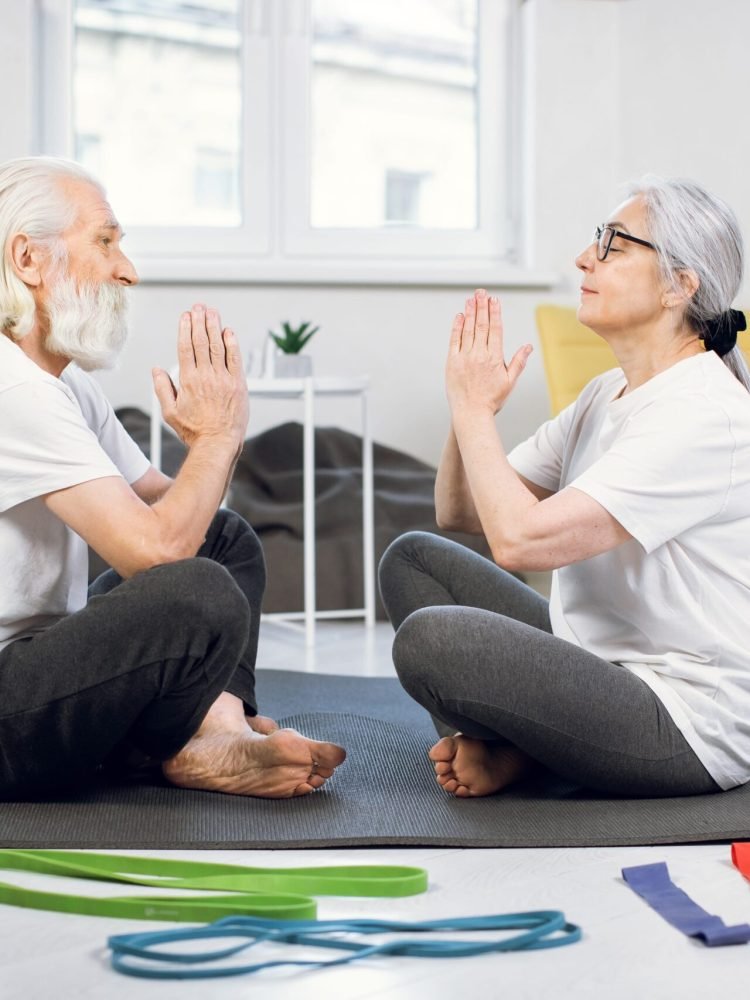 aged-couple-sitting-on-yoga-mat-face-to-face-and-m-2023-11-27-05-31-40-utc-min